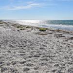 Strand mit feinem Sand und Wellen, das Meer ist klar und weit.