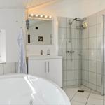 Bathroom with shower, sink and whirlpool tub. Window with blinds.