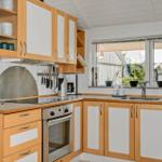 Kitchen with wooden cabinets, stainless steel appliances, and window view of outdoor area.