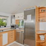 Kitchen with stainless steel appliances, wooden cabinets, and garden view.