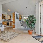 Apartment with kitchen, dining area, and bedroom. Entrance to terrace with view of garden.