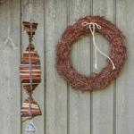 An der Wand hängen ein Kranz und ein Fisch aus Holzstäbchen.