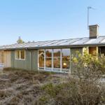 Moderne Strandhaus mit großem Fensterfront und Holzfassade im Freien.