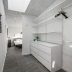 Schlafzimmer mit Dachschrägen, Kleiderschrank und Blick in den Flur.
