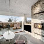 Wohnraum mit Kamin, Terrasse und Sitzgelegenheiten. Moderne Einrichtung und großzügige Fenster.