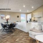 Moderne Küche, Essbereich und Wohnzimmer mit Holzboden und hellen Wänden.
