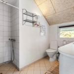 Badezimmer mit Dusche, Toilette und Waschbecken unter schrägem Dach