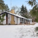 House with snow-covered roof and glass veranda in winter.