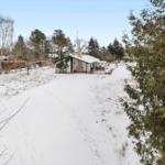 House on snow-covered land surrounded by trees