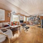 Living room with sofa, chair, bookshelf, and wooden floor.