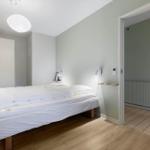 Bedroom with bed, wardrobe, and adjacent bathroom.