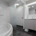 Bathroom with whirlpool, shower, and sink with mirror.