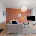 Living room with sofa, fireplace, and TV. Access to terrace.