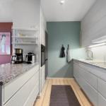 Kitchen with countertop, sink, and appliances. Wall colors pink and green.