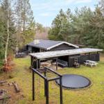 House with terrace, trampoline, and play area in the forest.