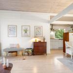 Living and dining area with wooden floor, white walls, and kitchen area in background.