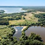 Aerial view showing a lake, river, and forested areas