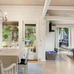 Dining area with table and chairs, living area with sofa and coffee table, view of garden and terrace.