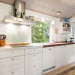Kitchen with white countertop, wooden surface, and window to the garden.