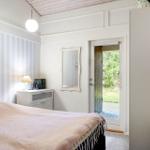 Bedroom with bed, nightstand, mirror, and door to the garden.