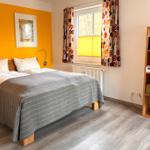 Schlafzimmer mit Bett, Fenster und Holzmöbel.