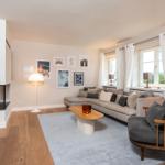 Wohnzimmer mit Sofa, Kamin und Holzboden.