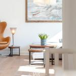 Wohnzimmer mit brauner Sitzgelegenheit, Holztisch und Wandbild mit Boot.