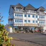 Fünfgeschossiges Haus mit Balkonen und Geschäft im Erdgeschoss.