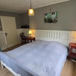 Schlafzimmer mit Bett, Nachttisch, Kleiderschrank und Wandbild.