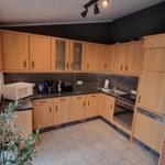 Küche mit Holzschränken, Arbeitsfläche und Fenster