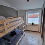 Zimmer mit Holz-Klappbett, Fenster und Heizkörper.