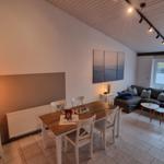 Wohn- und Essbereich mit Sofa, Tisch und Fenster.