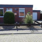 Rotes Backsteingebäude mit Fenstern und Garagen门前有修剪整齐的灌木和铺砌路面