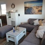 Living room with gray sofa, coffee table, and beach artwork on the wall.
