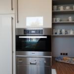 Kitchen with built-in oven, dishwasher, and dish cabinet.
