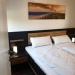 Bedroom with double bed, nightstands, and wall art.