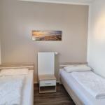 Two single beds with white bedding and nightstand