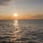 Sunset over the sea with reflection on the water surface.