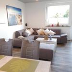 Living and dining area with sofa, table and chairs. Window and door to the terrace.