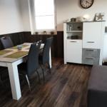 Dining area with table, chairs, and cabinet against the wall.