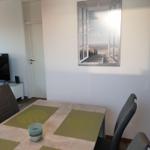 Dining table with chairs and wall picture of a beach.