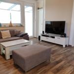 Living room with sofa, TV, and wooden floor.