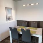 Dining room with table, four chairs, and wall picture.