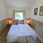 Schlafzimmer mit Bett, Fenster und Wandbildern