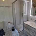 Badezimmer mit Dusche, Waschbecken und Toilette.