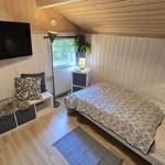 Schlafzimmer mit Bett, Fernseher und Fenster.