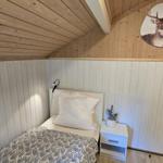 Schlafzimmer mit Bett, Nachttisch und Wandbild von Hirsch.