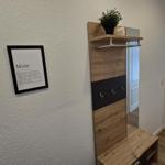 Eingangsbereich mit Garderobe, Wandbild und Blick in Wohnzimmer.