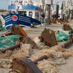 Fischerboote und Netze am Hafen
