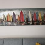 Wandbild mit bunten Segelbooten über grauem Sofa